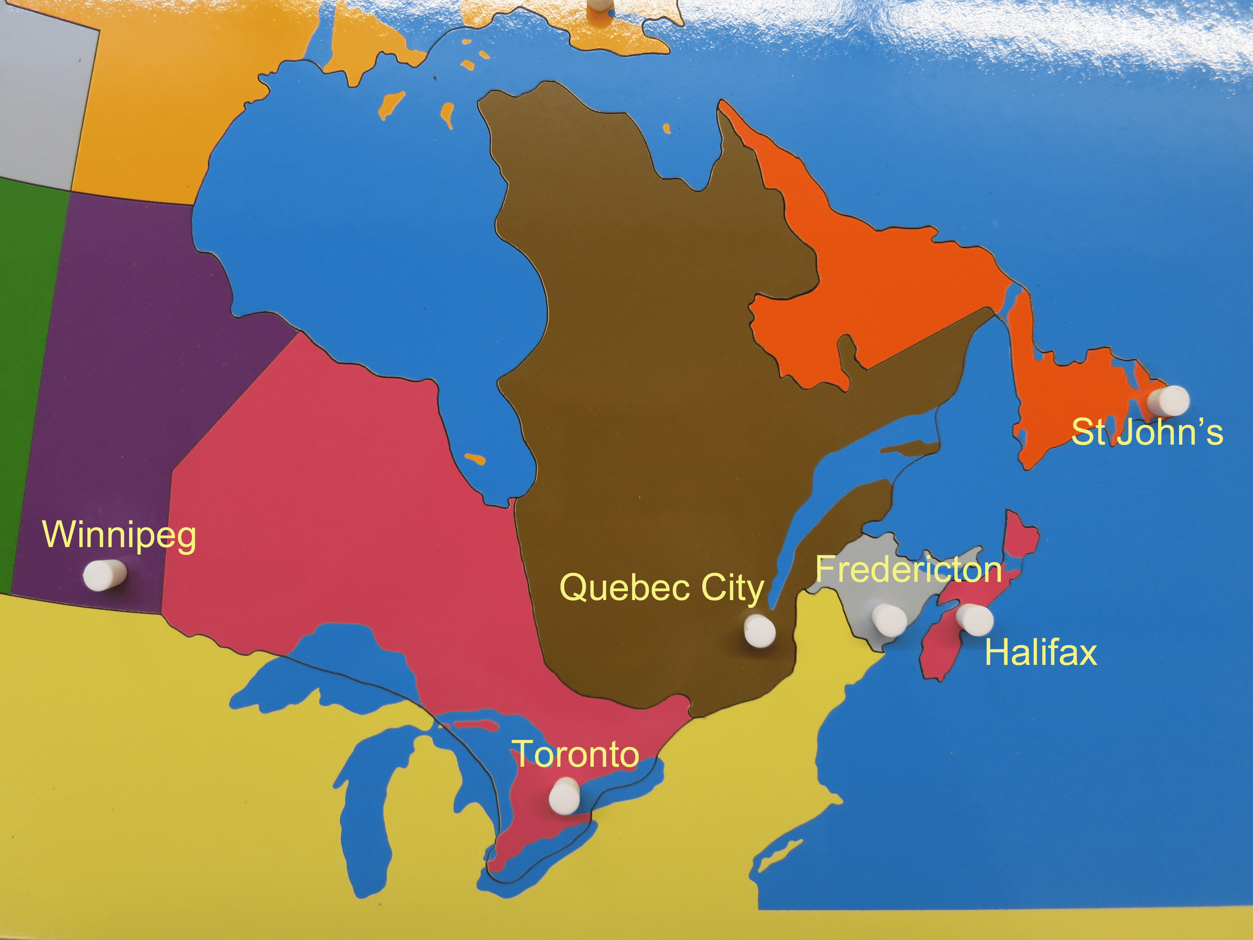 Montessori geography puzzle map of Canada with knobs on capital cities.