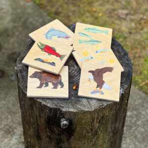 Wooden coasters featuring images of sockeye salmon lifecycle, grizzly bear and bald eagle.