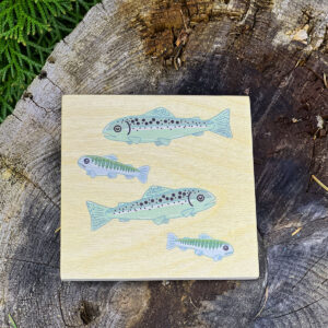 Wooden coaster with images of juvenile salmon.