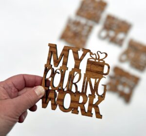 Hand holding coaster with blurred images of other coasters in background.