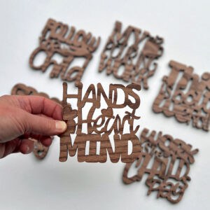 Hand holding coaster with blurred images of other coasters in background.