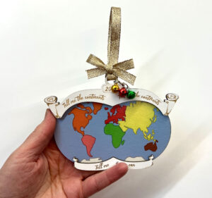 Montessori Continent Song Christmas Ornament holding in hand.