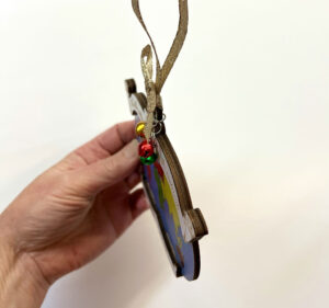 Montessori Continent Song Christmas Ornament holding in and angle in hand.